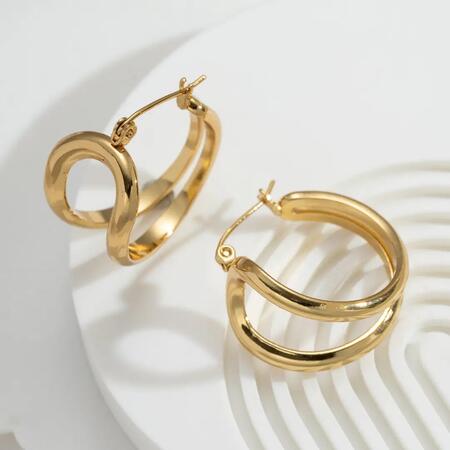 Spesse creole dorate in acciaio inossidabile con lucentezza scultorea